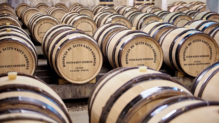 The wine barrels of the Hospices de Nuits-St.-Georges sit aging in the charity's cellars. Money from sales of the wine finances its health care mission.